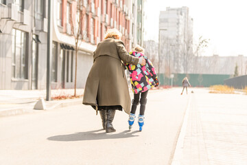 grandmother teaches granddaughter to roller skate
