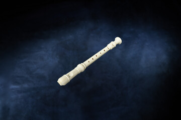 white woodwind musical instrument soprano flute recorder on black background