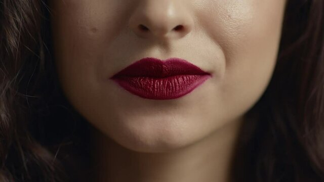 Sensual girl biting sexy plump lips. Close up view of young female face.