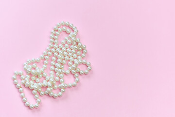 Feminine desktop mockup with pearls on pink background with copy space.