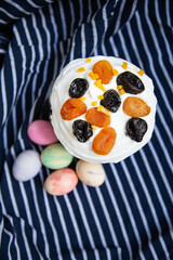 Easter eggs decorated with watercolors and Easter cake lie on a striped blue apron. Easter religious holiday concept, top view.