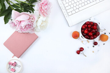 Modern woman's desktop, home office, cup with cherries and peonies on a light table. Healthy breakfast with ingredients, healthy lifestyle concept, flat lay, selective focus