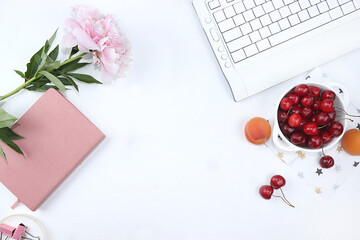 Modern woman's desktop, home office, cup with cherries and peonies on a light table. Healthy breakfast with ingredients, healthy lifestyle concept, flat lay,