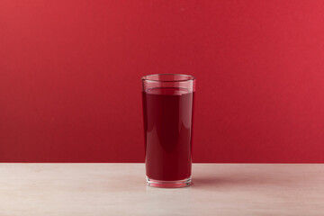 Salgam - popular Turkish drink, made from fermented purple carrots, turnips or beets. Glass on red...