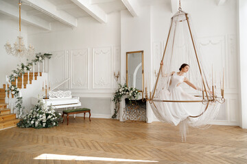 dancer in a white on a chandelier near the piano
