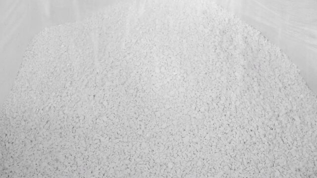 White hard grinded plastic comes out of the cyclone of the machine by pneumatic transport into the big bag. concept of recyclable materials, plastic recycling, pellet production plants