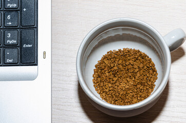 Notepad, laptop and coffee cup on wood table. View from above