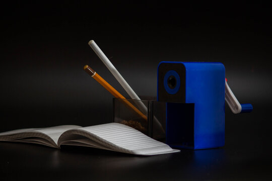 manual pencil sharpener blue with note on black background