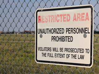 Restricted area sign on chain link fence
