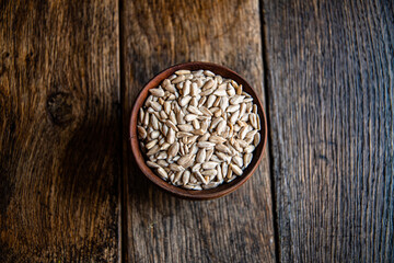 Peeled sunflower seeds in a wooden bowl on a wooden table. Bakery ingredients. Products for tasty and healthy food.