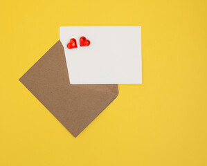 Greeting card mockup, white blank card with paper envelope and hearts on yellow background. Blank love letter, valentine's day, wedding invitation