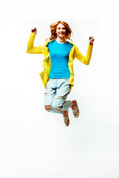 pretty young redhad teenage girl jumping happy smiling on white background, lifestyle people concept