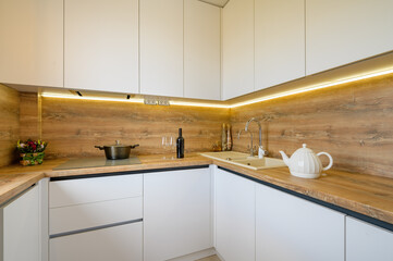 Fototapeta na wymiar Modern white and beige wooden kitchen interior details