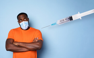 Man with face mask has a lot of questions and doubts about covid 19 vaccine. cyan background