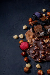 Fototapeta na wymiar Chocolate bar, crushed pieces of dark chocolate and nuts. Praline Chocolate sweets