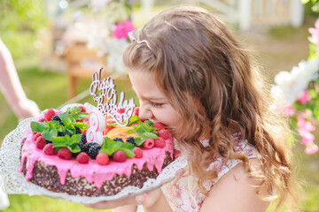 girl take bite of off piece of congratulatory cake. Birthday and congratulations concept.