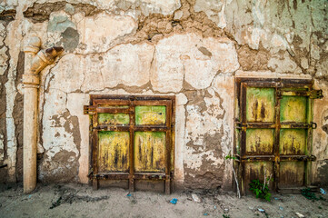 Aouli, Morocco - April 10, 2015. Green rusty doors of abandoned house, partly buried by sand