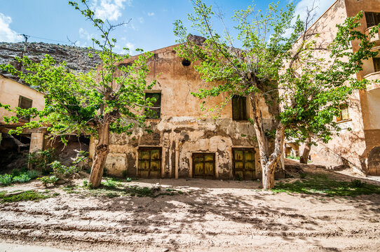 Aouli, Morocco - April 10, 2015. Green rusty doors of abandoned house, partly buried by sand