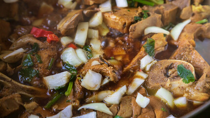 Pork chops in a boiling stewed with parsley, onion and readseasoning pepper