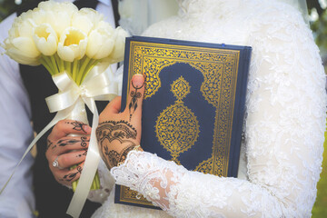 Islam wedding ceremony Muslim bride holding a quran and bouquet close up