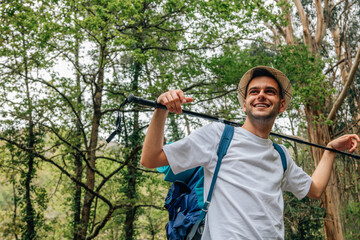 young adventurer with backpack smiling in the forest