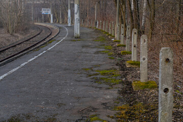 Naklejka premium Old, dilapidated and abandoned railway station with rusty railway tracks and wooden railway sleepers