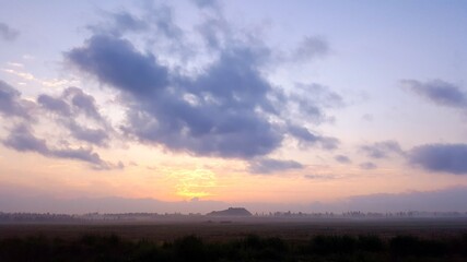 Natural Sunset Sunrise Over Field Or Meadow. Bright Dramatic Sky And Dark Ground. Countryside Sun Over Skyline, Horizon. Cold Colours