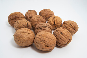 Vista de un montón de nueces con propiedades antioxidantes, cardiosaludables y beneficiosas para controlar el colesterol, aisladas sobre fondo blanco.