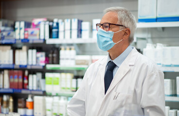 Pharmacist working in his pharmacy, coronavirus concept