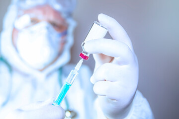 A Doctor wearing surgical mask and surgical gloves holding a needle for injection of medicine or vaccination   on white background 