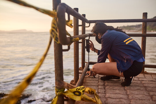 mujer joven con mascarilla feliz en la playa. Momento de relajacion a orillas del mar durante un atardecer. Fondo de olas y mar