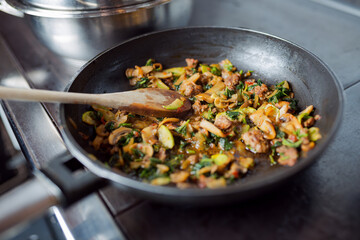 Delicious food with mushrooms and Zucchini in frying pan