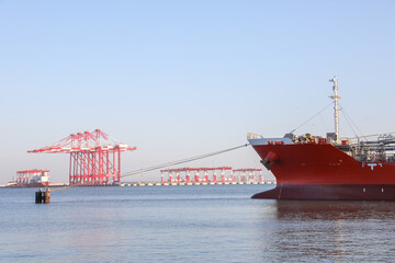 Oil tanker ship loading in port. Fuel tanker ship docked in industrial area. LPG tanker.