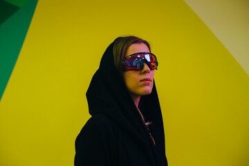 girl in sunglasses on the background of a colored wall