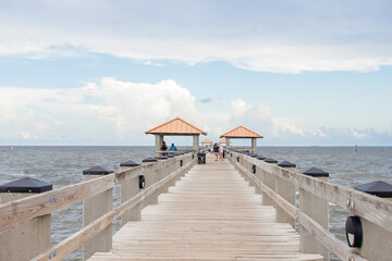 Fototapeta premium Seascape. Wooden pier with gazebos with orange roofs. Summer background. Ken Combs Pier, Gulfport, MS, USA