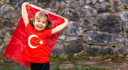 Portrait of happy little kid. Cute baby with Turkish flag t-shirt. Toddler hold Turkish flag in...