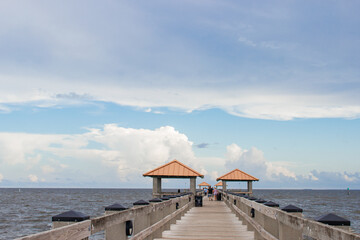 Seascape. Wooden pier with gazebos with orange roofs. Summer background. Ken Combs Pier, Gulfport, MS, USA