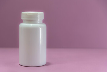 Milky white plastic bottle for storing medicine on pink background