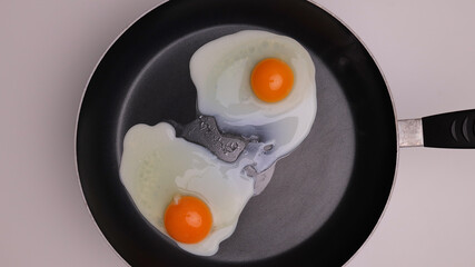 Fry two eggs sunny side up in a pan - studio photography