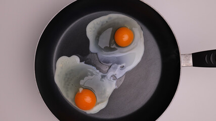 Fry two eggs sunny side up in a pan - studio photography