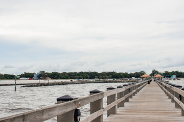 Fototapeta premium Seascape. Wooden pier with gazebos with orange roofs. Summer background. Ken Combs Pier, Gulfport, MS, USA