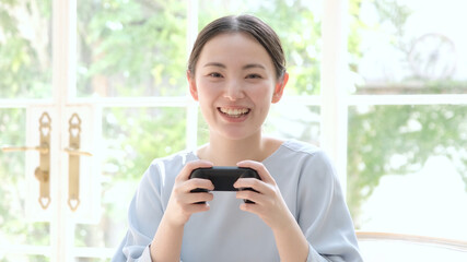 テレビゲームをプレイする若い女性