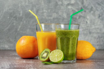 Two tall glasses of orange juice and a banana-orange kiwi and spinach smoothie