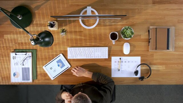 Top view of businessman working at desk in home office.