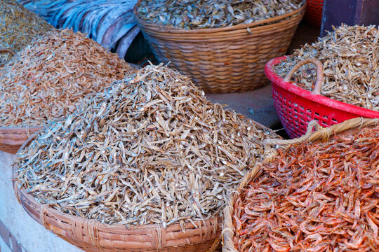different variety of dry fishes stored in a basket for sell in a market stall