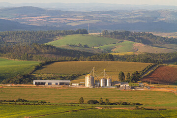 rural landscape of green field with mountain and grain silo