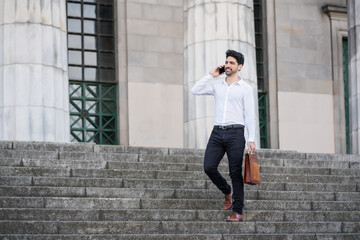 Obraz premium Businessman talking on the phone outdoors.
