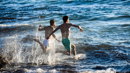 Fototapeta premium Young people running to the sea