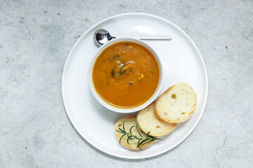sup labu or pumpkin soup serving with slice of baguette