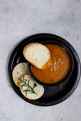 sup labu or pumpkin soup serving with slice of baguette